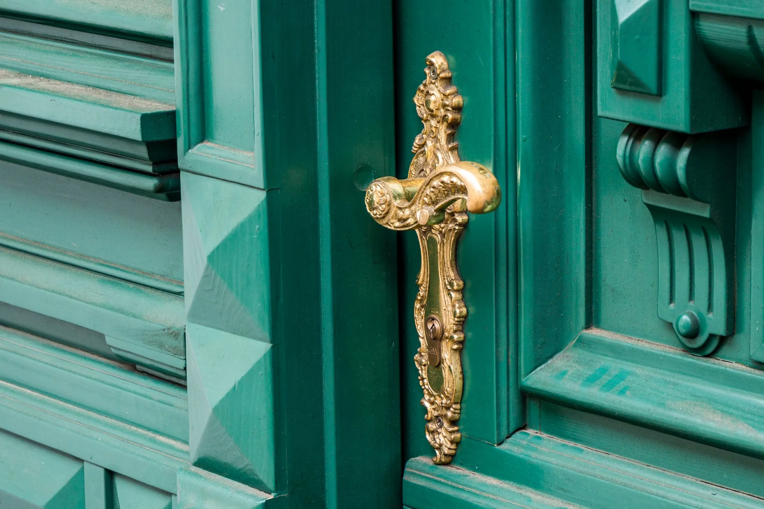 Poignée de porte en laiton fixée sur une porte intérieure en bois clair
